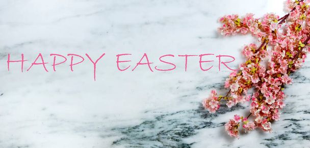 Szczęśliwa koncepcja Wielkanocy z wiosennymi kwiatami wiśni na kamiennym tle plus dodana wiadomość tekstowa - Zdjęcie, obraz