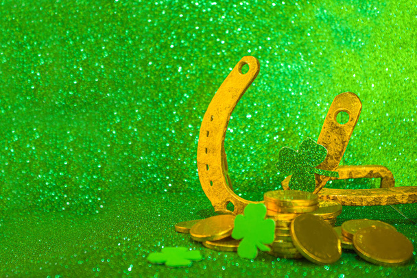 Fondo de saludo del día de San Patricio. Venta de Patrick, plantilla de invitaciones, menú. Con símbolos navideños - herradura dorada, trébol verde, sombrero de duende, monedas de oro, fondo bokeh verde - Foto, imagen
