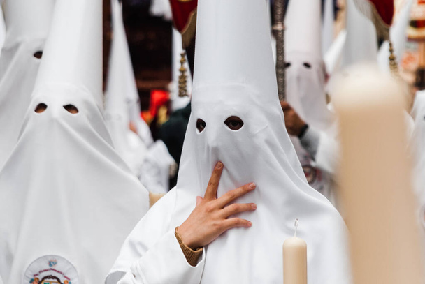 penitents in a white dressed Easter procession in Almera, southern Spain. - Photo, Image