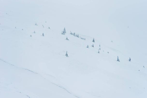 Ongelooflijk winterlandschap. bergen bedekt met sneeuw en blauwe bewolkte lucht - Foto, afbeelding
