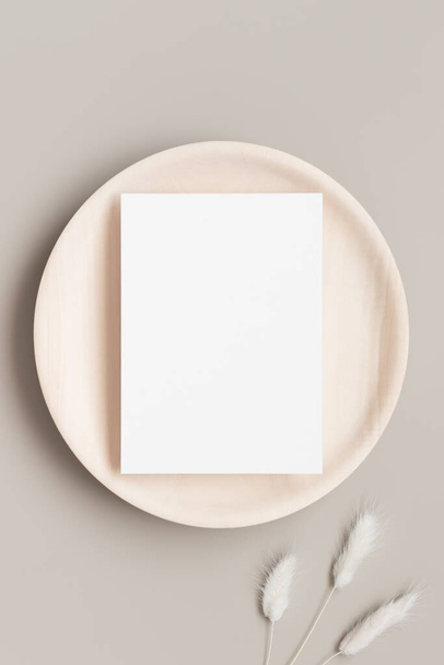 Біла картка запрошення макет на дерев'яній тарілці з прикрасою лагуни. 5x7 співвідношення, подібне до A6, A5
. - Фото, зображення