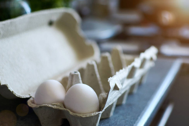 Chicken eggs in a tray on the kitchen table. Preparing breakfast preparation. - Foto, Imagen