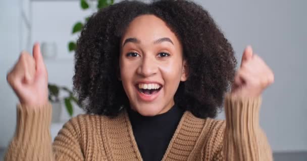 Porträt einer erfolgreichen afroamerikanischen Frau ethnische Mädchen jubelt Erfolg Triumph fühlt Glück Freude schreien Bewegungen Hände tanzen feiern gute Nachrichten zu Hause, glückliche weibliche Gesicht aus nächster Nähe - Filmmaterial, Video
