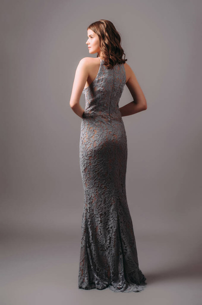 Grey lace evening dress. Beautiful model in bridesmaid dress, modern feminine look for an event. Women's fashion. Adorable lady in long chiffon trumpet dress. - Φωτογραφία, εικόνα