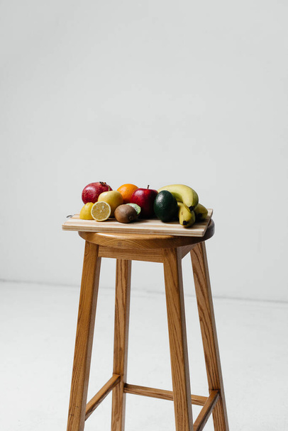 Assorted ripe fruit on a wooden Board on a white background. Healthy diet - Φωτογραφία, εικόνα