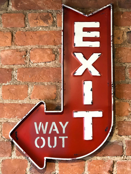 Close-up van Vintage rood bord Exit / Way Out, retro stijl op de bakstenen muur van het gebouw - Foto, afbeelding