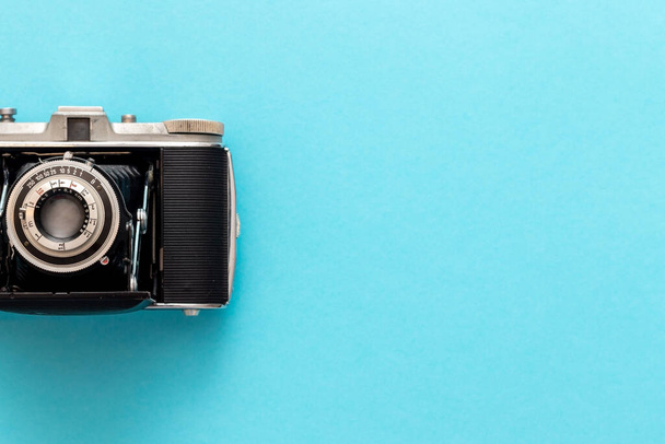 Old retro camera seen from top view in flat lay against blue pastel showing nostalgic feeling. - Photo, Image