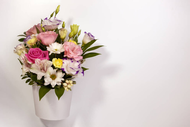 flat lay bouquet of roses, daisies, lisianthus, chrysanthemums, unopened buds in white paper box on a white background - Fotoğraf, Görsel