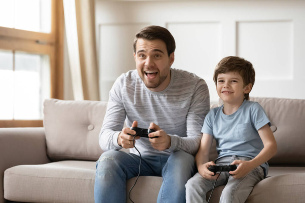 Happy dad and little son play video game - Foto, Imagen