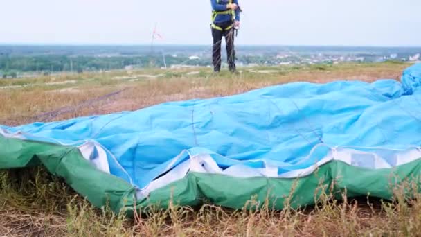 Imagem de close-up da asa de paraquedas deitada na grama no campo após a aterrissagem pára-quedista - Filmagem, Vídeo