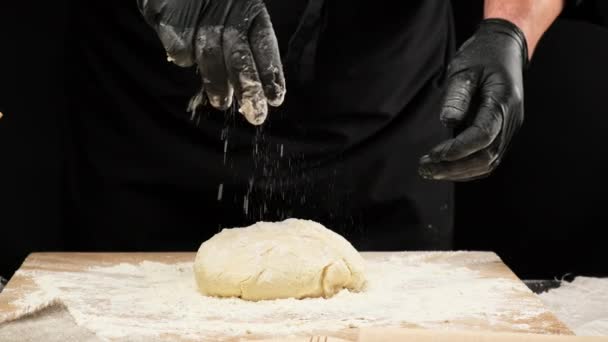 chef en un delantal a rayas amasa una bola de masa de harina de trigo blanco en la mesa, cámara lenta - Imágenes, Vídeo