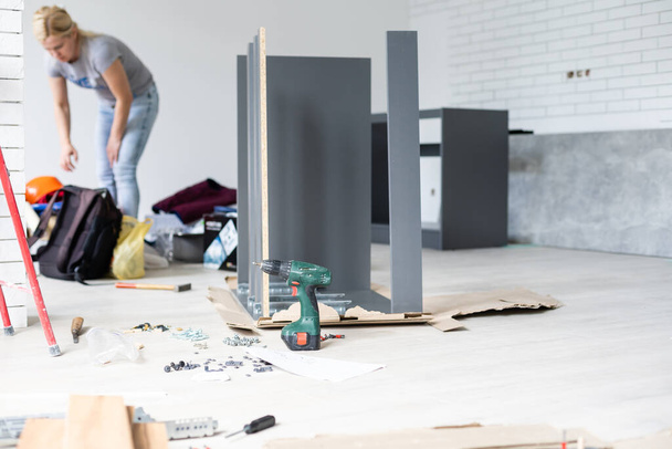 furniture, home and moving concept, installation and assembly of furniture in a new apartment - Foto, Bild