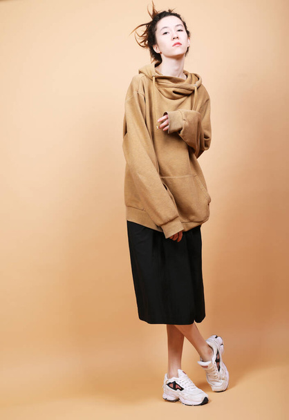 Fashion Model, Fashion, Teenage Girls concept. Young brunette woman posing over beige background. - Fotoğraf, Görsel