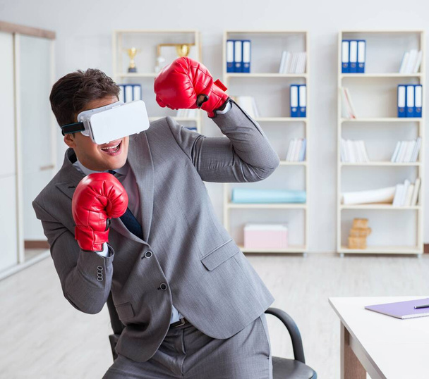Mann boxt im Büro mit Virtual-Reality-Brille - Foto, Bild