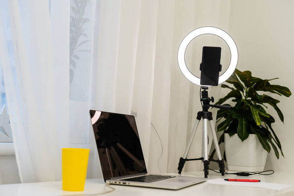 lámpa és állvány az asztalon az online interjúk mögött egy laptop - Fotó, kép