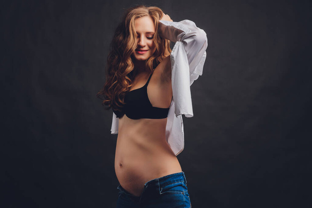 Young beautiful stylish pregnant woman posing in black underwear. - Фото, зображення