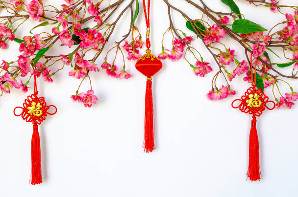Hanging pendants for Chinese new year ornament (meaning of word is wealth) with Chinese blossom flowers on white background. - Photo, Image
