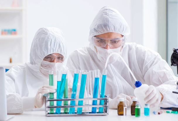 Два учёных, работающих в химической лаборатории - Фото, изображение