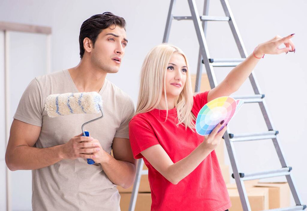 Νεαρή οικογένεια ζωγραφίζει κατά τη διάρκεια ανακαίνισης σπιτιού - Φωτογραφία, εικόνα