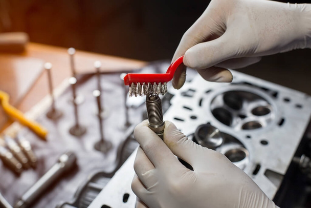 Auto mechanic working in garage. Repair service.  opened automobile engine cylinder head for maintenance repair at car service station for diagnosis  - Fotoğraf, Görsel