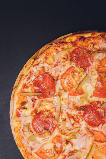 Pizza pepperoni, mozzarella, oregano on a black background. - Zdjęcie, obraz