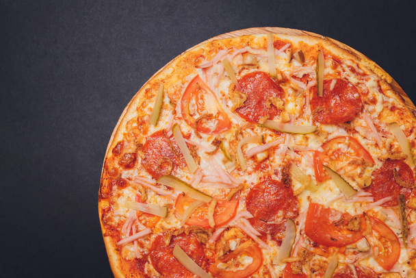 Pizza pepperoni, mozzarella, oregano on a black background. - Foto, Imagen