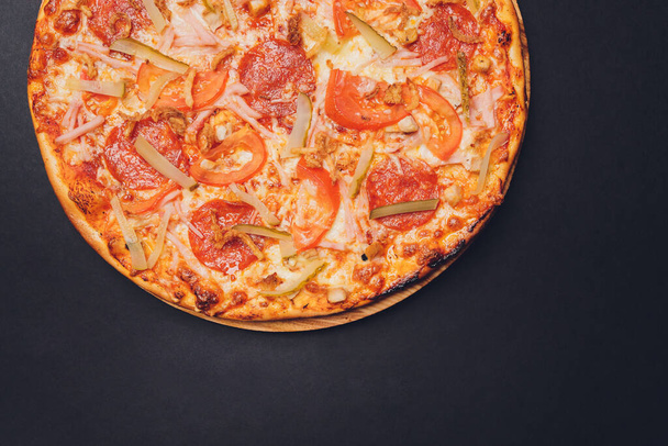 Pizza pepperoni, mozzarella, oregano on a black background. - Foto, Imagem