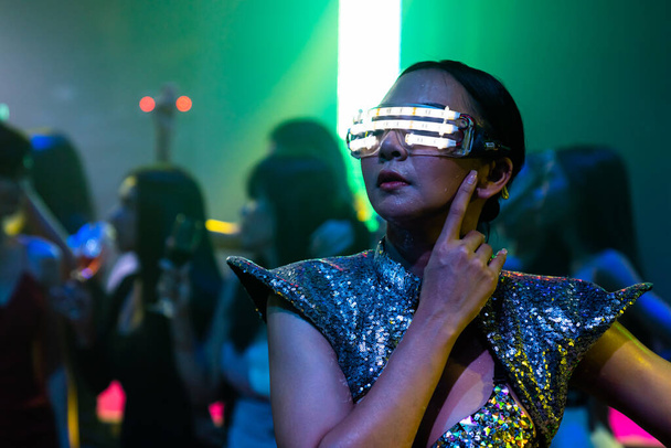 Техно танцовщица в ночном клубе танцует под ритм музыки от DJ - Фото, изображение