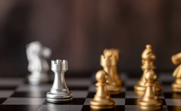Серебряные и золотые шахматы на доске и деревянном фоне - Фото, изображение
