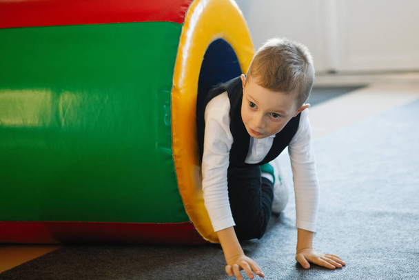 Junge klettert auf Kinderspielplatz aus Spielzeugpfeife Glückliche unbeschwerte Kindheit. Selektiver Fokus. - Foto, Bild