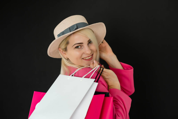 Mujer de compras sosteniendo bolsas, aisladas sobre fondo negro. concepto de viernes negro - Foto, Imagen