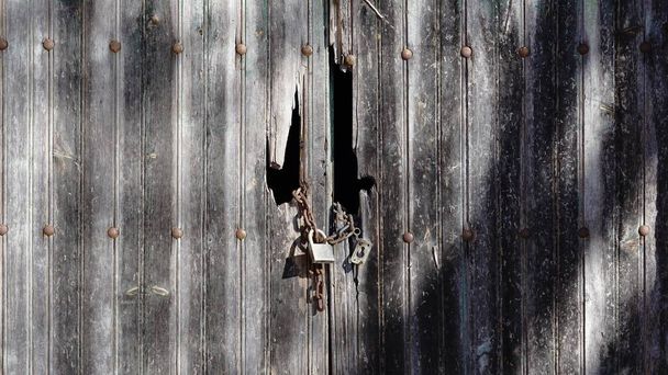 старая деревянная дверь закрыта цепью и замком - Фото, изображение
