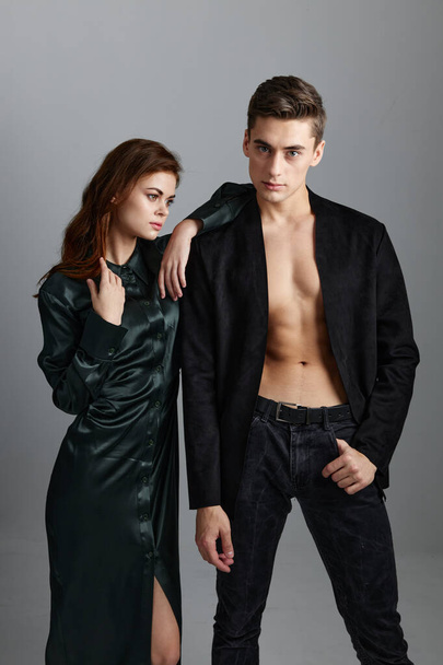 A man in a jacket and trousers stands next to a woman on a gray background cropped view - Photo, Image