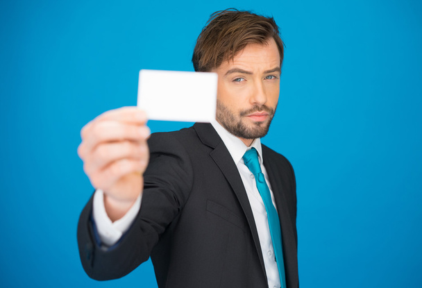 guapo hombre de negocios mostrando tarjeta de visita en blanco
 - Foto, Imagen