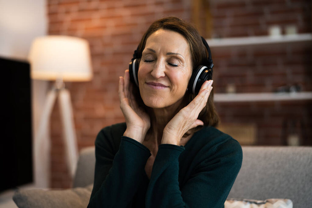 Smiling Woman Listening Music Using Headphones In Living Room - Zdjęcie, obraz