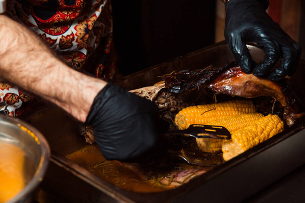 El chef saca el maíz horneado del molde con pinzas - Foto, imagen