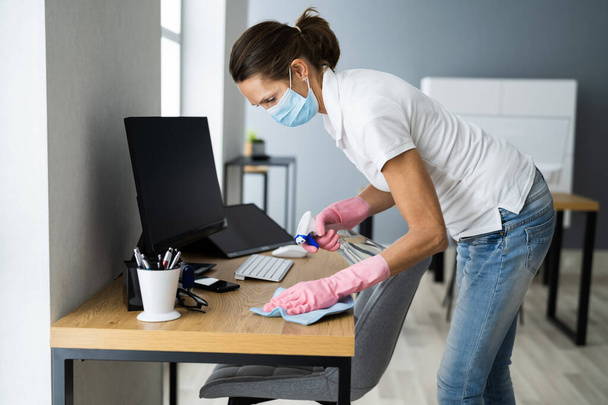Office Desk Cleaning Service. Professional Janitor In Face Mask - Valokuva, kuva