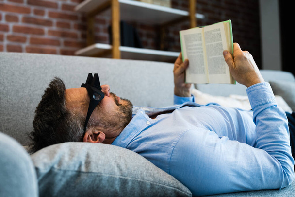 Man Using Lazy Reading Prism Glasses To Read Book - Фото, изображение
