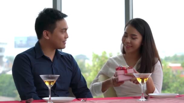 Romantyczna para daje prezent kochankowi w restauracji - Materiał filmowy, wideo