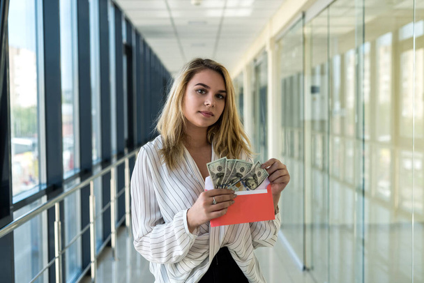 young lady holding an envelope and counting dollars in job. bribe concept - Photo, Image