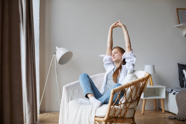 Happy woman resting comfortably on chair at home. Good weekend. - Foto, imagen