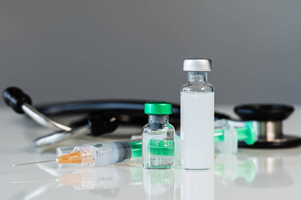 vaccine bottles and syringe injection medicine and stethoscope - Foto, imagen