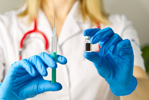 manos del médico inyectando una aguja de jeringa en un frasco pequeño con una vacuna o medicamento asignar virus o gripe. - Foto, Imagen