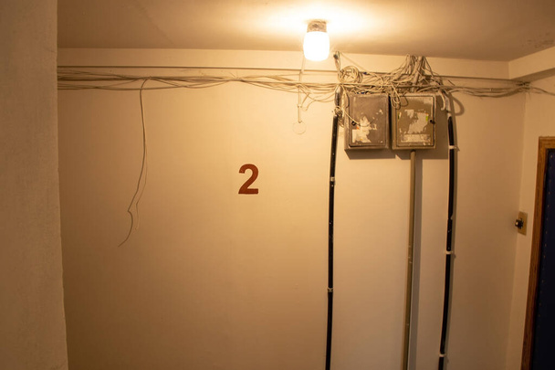 vecchia sporca scala scura sovietica in un condominio nella città di dnipro in Ucraina, il numero di piano sul muro è scritto 2 - Foto, immagini