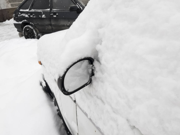 Araba karla kaplı ve karın altından sadece ayna görülebiliyor.. - Fotoğraf, Görsel
