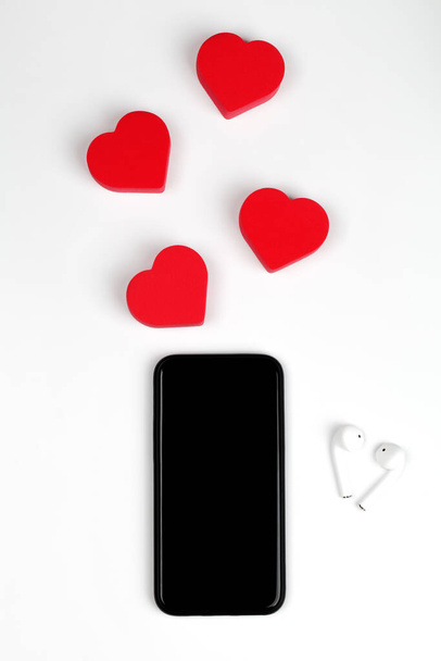 Офіційна робота з червоними серцями, телефоном, навушниками. Valentines Day concept with space for Your text and picture - Фото, зображення