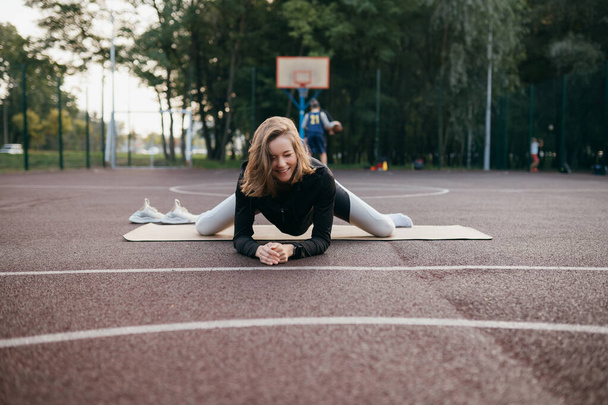 Young fit woman in sportswear trains outdoors on the playground. - Foto, Bild