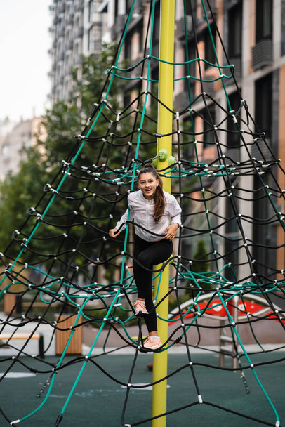 Young woman having fun on the rope pyramid - Zdjęcie, obraz