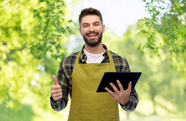 happy male gardener or farmer with tablet pc - Фото, изображение