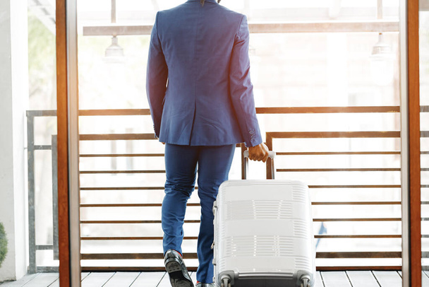 Unrecognizable businessman standing with luggage suitcase in hotel lobby - Foto, Bild